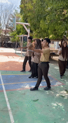 School students drill and play volleyball on an outdoor court