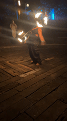 Fire dancer performs at nighttime outdoor event in Penebel