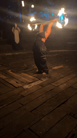 Fire dancer performs at nighttime outdoor event in Penebel