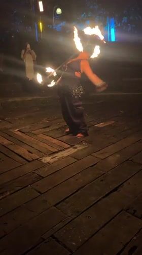 Fire dancer performs at nighttime outdoor event in Penebel