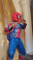 Child plays in Spider-Man costume on bed in Nigeria
