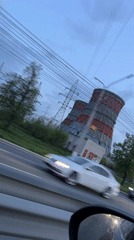 Passenger films cooling tower from moving car in Cheboksary