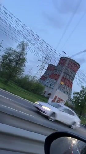Passenger films cooling tower from moving car in Cheboksary