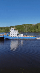 Tugboat pulls barge through Russian canal lock, passenger catches fish