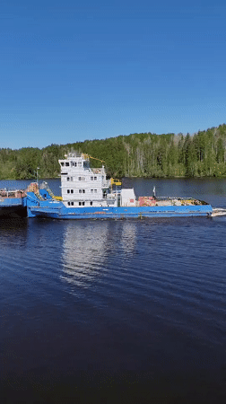 Tugboat pulls barge through Russian canal lock, passenger catches fish