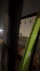 Vehicle operator documents Indonesian industrial area, dashboard during daytime drive