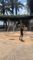 Young person plays barefoot in Haifa water park fountains