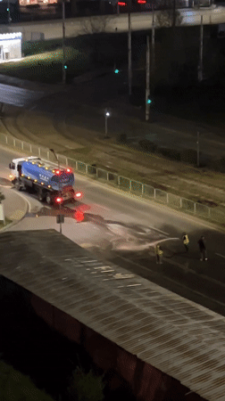 Night road maintenance crew sprays Sofia street