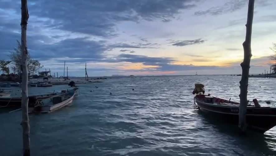 Sunset fishing boats captured at Thai coastal village harbor