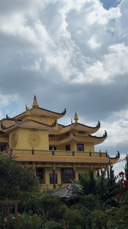 Ornate yellow Asian-style building captured in Da Lat gardens