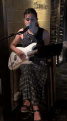 Solo guitar performance against a brick wall in Barcelona