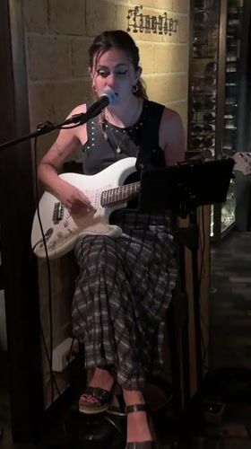 Solo guitar performance against a brick wall in Barcelona