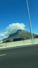 Highway drive captures Cape Town mountain views on sunny day