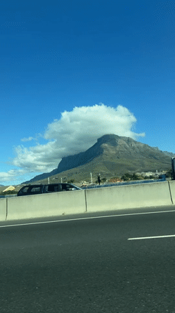 Highway drive captures Cape Town mountain views on sunny day