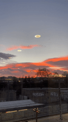 Sunset illuminates Sabadell cityscape through clouds