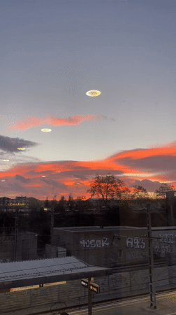 Sunset illuminates Sabadell cityscape through clouds
