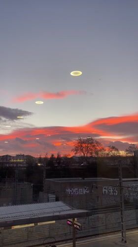 Sunset illuminates Sabadell cityscape through clouds