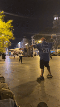 Young people skateboard, play basketball in Barcelona plaza