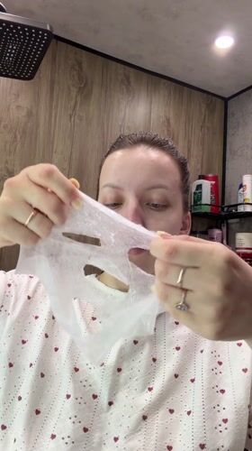 Woman applies facial mask during morning skincare routine