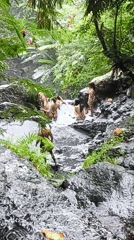 Women visit tropical waterfall pool in Sidemen, Indonesia