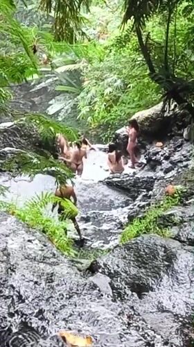 Women visit tropical waterfall pool in Sidemen, Indonesia