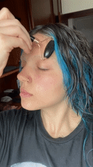 Woman performs facial roller skincare routine in Gijón, Spain