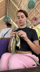 Woman crochets at outdoor cafe in North Kuta