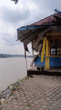 Damaged riverside building documented in Simpangjaya, Indonesia morning footage
