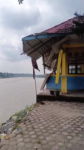 Damaged riverside building documented in Simpangjaya, Indonesia morning footage