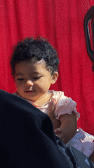 Baby girl photographed smiling while held in Parci, Montenegro