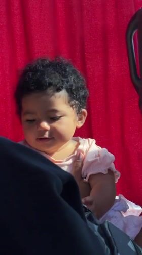 Baby girl photographed smiling while held in Parci, Montenegro