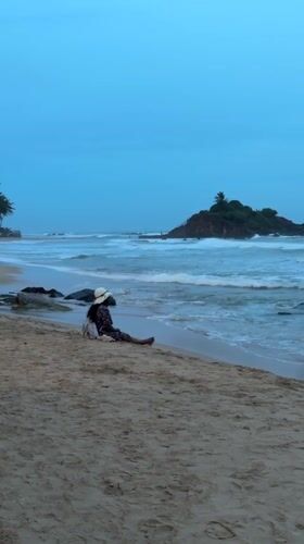 Woman enjoys dusk beach moment in Mirissa, Sri Lanka