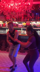 Couple dances salsa in red-lit Pattaya bar