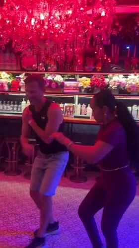 Couple dances salsa in red-lit Pattaya bar