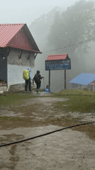 Trekkers navigate muddy path in misty conditions at Dhampus Phedi