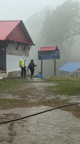 Trekkers navigate muddy path in misty conditions at Dhampus Phedi