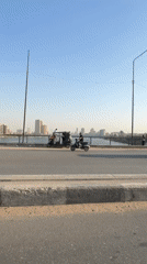 Traffic flows on Cairo waterfront bridge during sunny afternoon