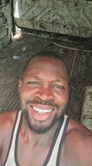 Man smiles for camera while riding in vehicle in Lagos
