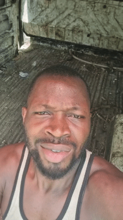 Man smiles for camera while riding in vehicle in Lagos