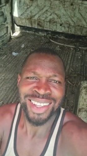 Man smiles for camera while riding in vehicle in Lagos