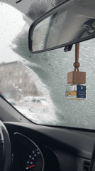 Person clears snow from car windshield in May weather