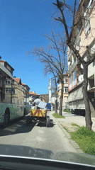 Man drives yellow cargo cart through Bulgarian town