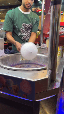 Al Sahaba Mosque glows at night, cotton candy nearby
