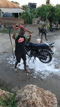 Motorcycle washing activity observed in Dar es Salaam neighborhood