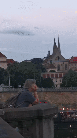 Prague's Vltava riverfront at dusk, castle and spires on the skyline