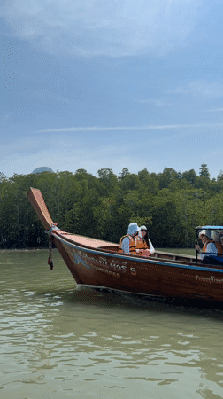 Longtail boats cruise Thailand waters with passengers aboard
