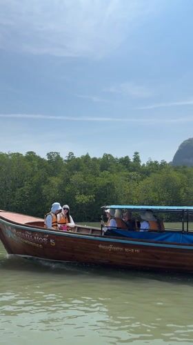 Longtail boats cruise Thailand waters with passengers aboard