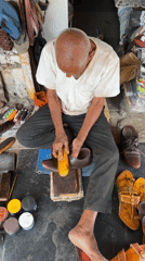Elderly man sits cross-legged in Shahapur, India