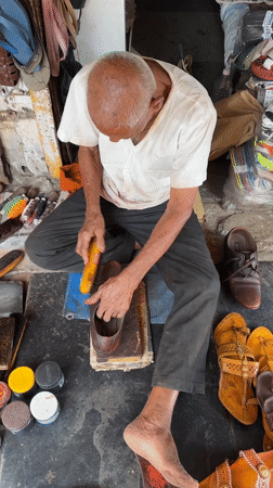 Elderly man sits cross-legged in Shahapur, India