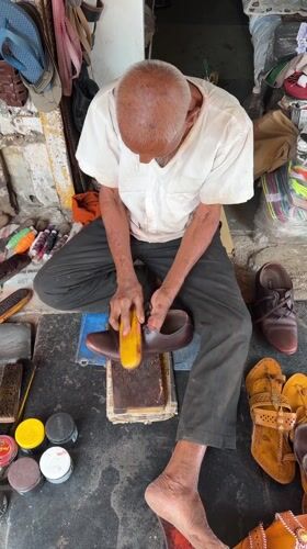 Elderly man sits cross-legged in Shahapur, India